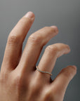 Close-up of the Pernelle curved French pave diamond wedding band worn on a woman's finger.