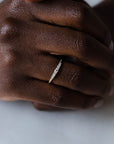 Close up of model hand wearing the seven stone Elsie womens wedding band by Fluid Jewellery in yellow gold