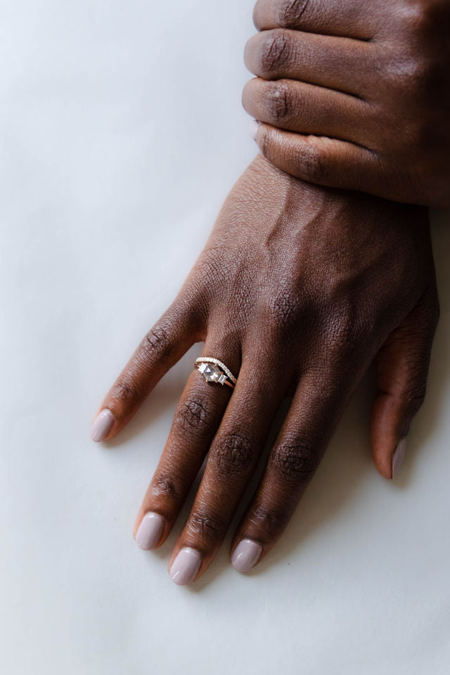Model wearing the Three Stone Alice Solitaire Engagement Ring in gold by Fluid Jewellery