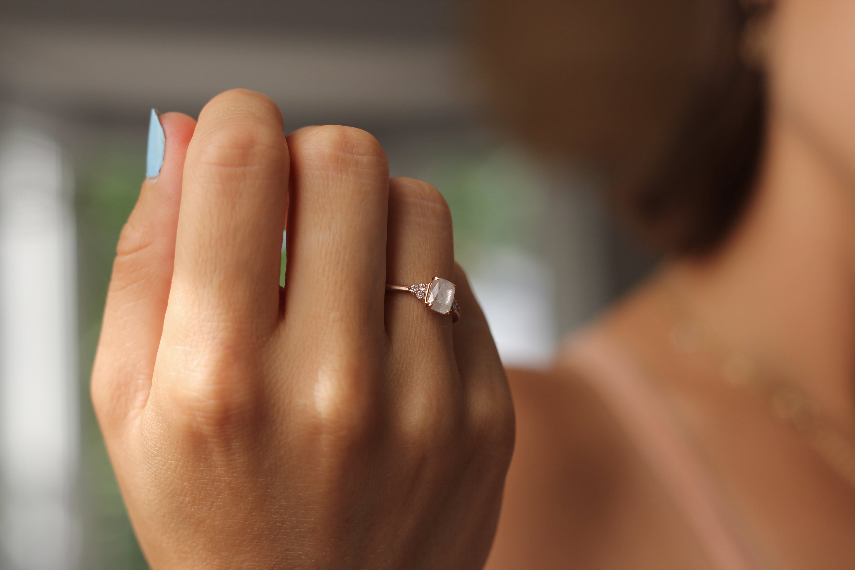 Model wearing the Cluster Aria Solitaire Engagement Ring in rose gold by Fluid Jewellery