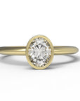 Close up of the Bezel Isla Solitaire Engagement Ring in yellow gold by Fluid Jewellery