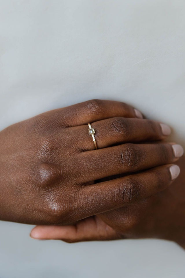 Model wearing the Accented Bri Solitaire Engagement Ring in yellow gold by Fluid Jewellery