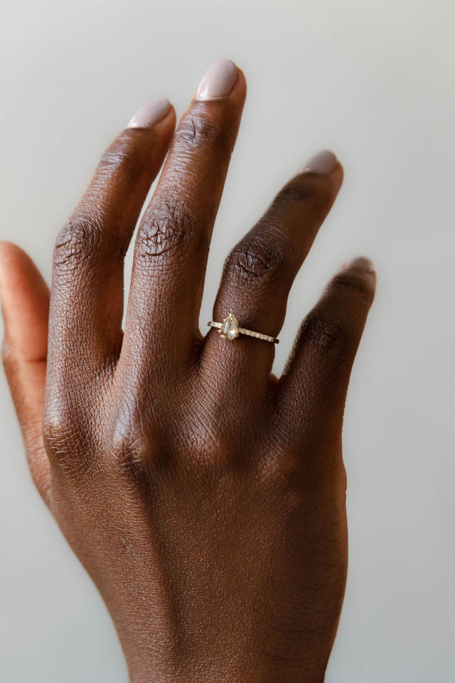 Model wearing the Accented Daphne Solitaire Engagement Ring in yellow gold by Fluid Jewellery