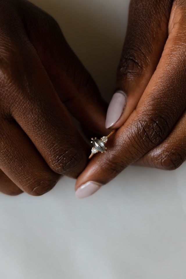Model wearing the Three Stone Elizabeth Engagement Ring in yellow gold by Fluid Jewellery