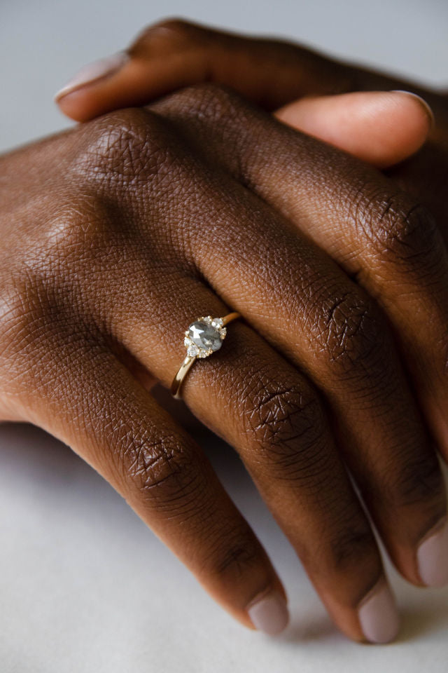 Model wearing the Cluster Matilda Solitaire Engagement Ring in yellow gold by Fluid Jewellery