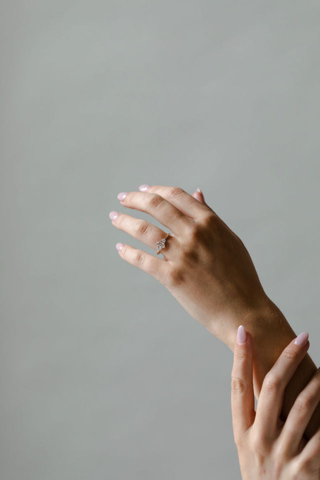 Model wearing the Three Stone Rebecca Solitaire Engagement Ring in yellow gold by Fluid Jewellery