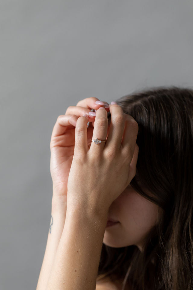 Model wearing the Three Stone Rebecca Solitaire Engagement Ring in yellow gold by Fluid Jewellery