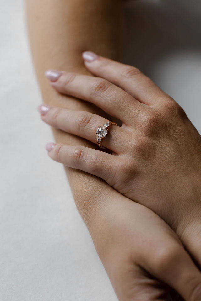 Model wearing the Three Stone Sadie Engagement Ring in yellow gold by Fluid Jewellery