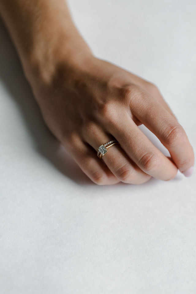 Model wearing the Cathedral Sage Solitaire Engagement Ring in yellow gold by Fluid Jewellery 4