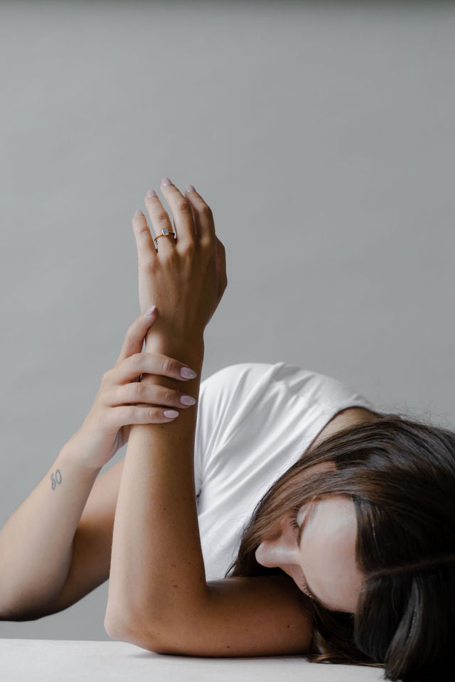 Model wearing the Cathedral Sage Solitaire Engagement Ring in yellow gold by Fluid Jewellery 5