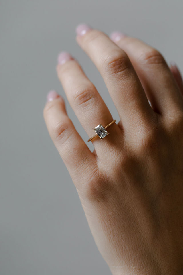 Model wearing the Cathedral Sage Solitaire Engagement Ring in yellow gold by Fluid Jewellery
