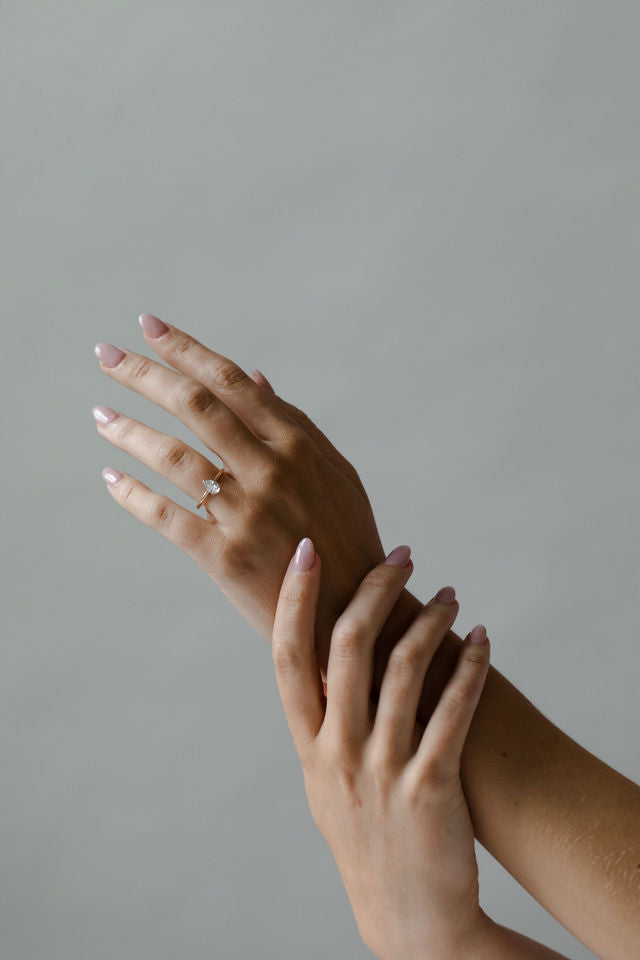 Model wearing the Classic Sula Solitaire Engagement Ring in gold by Fluid Jewellery
