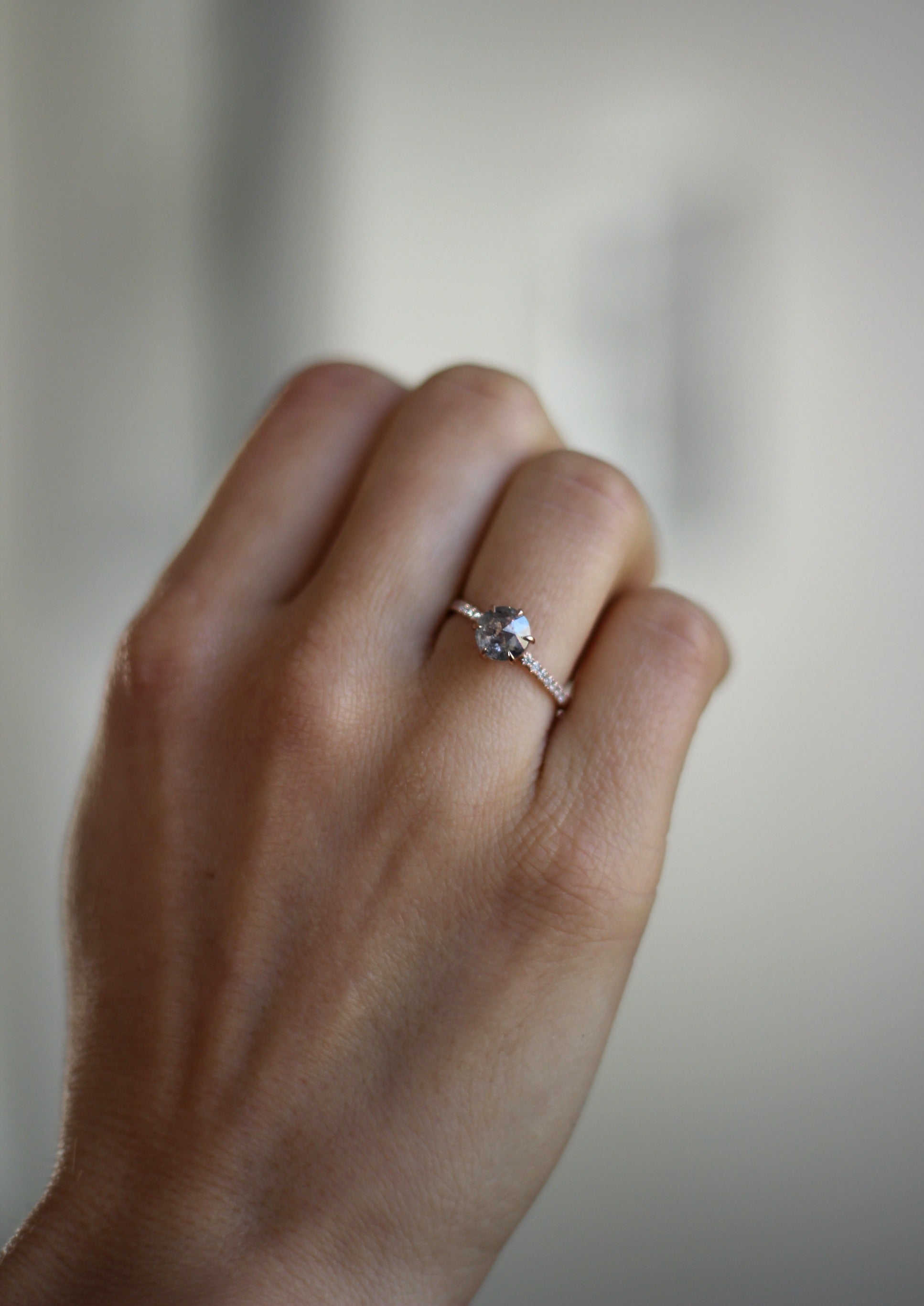Model wearing the Accented Zoe Solitaire Engagement Ring in rose gold by Fluid Jewellery