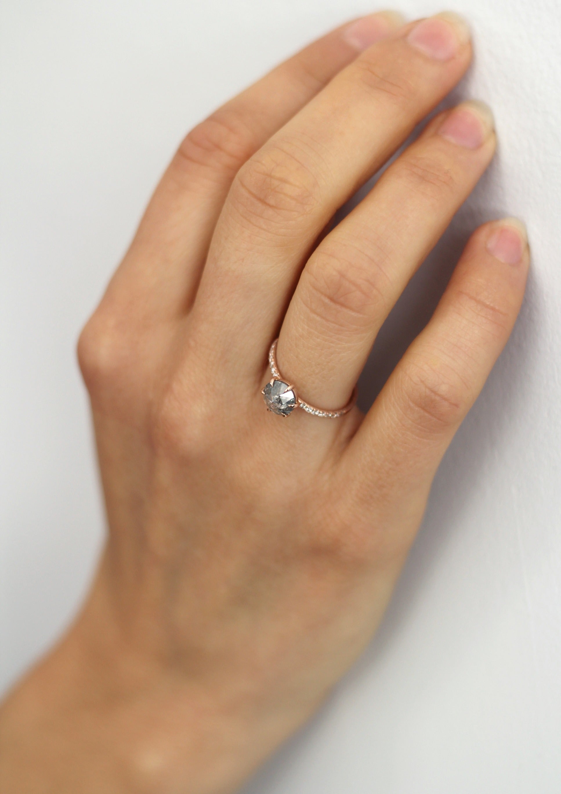 Model wearing the Accented Zoe Solitaire Engagement Ring in rose gold by Fluid Jewellery 2