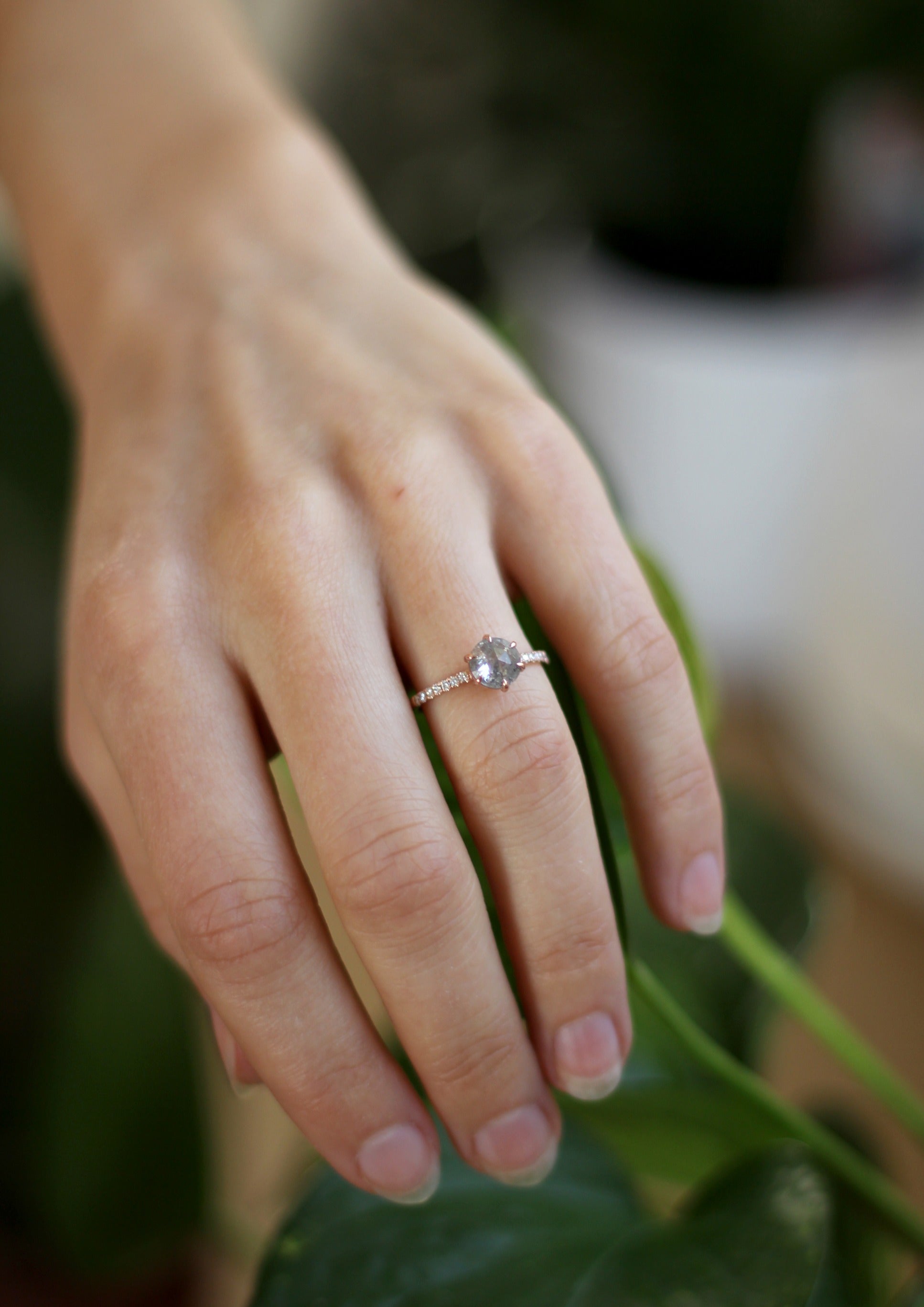 Model wearing the Accented Zoe Solitaire Engagement Ring in rose gold by Fluid Jewellery 3