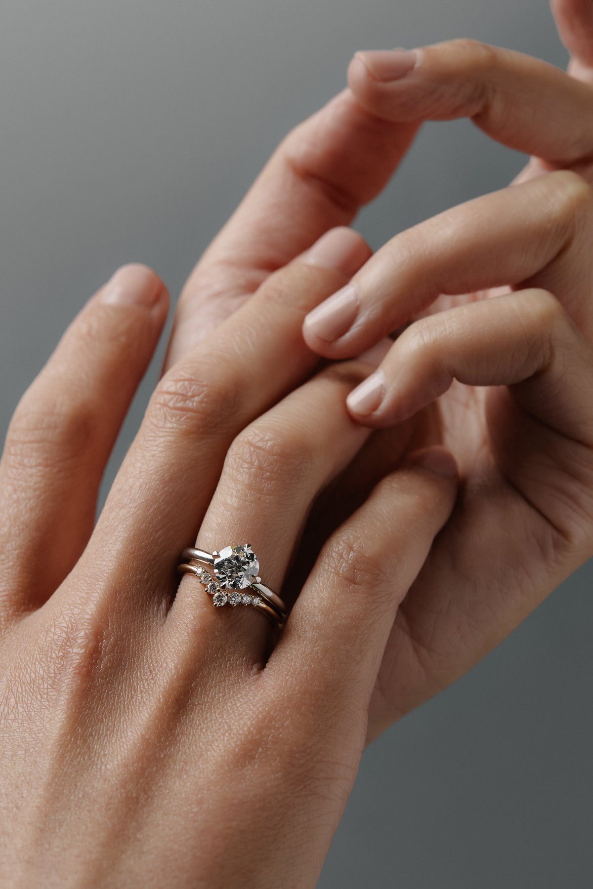 Claudia chevron Fairmined gold wedding band paired with the Compass solitaire engagement ring on a woman's hand.