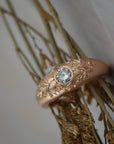 Close-up of the hand engraved floral details on the side of the Mrs. Erykah Fairmined gold engagement ring.