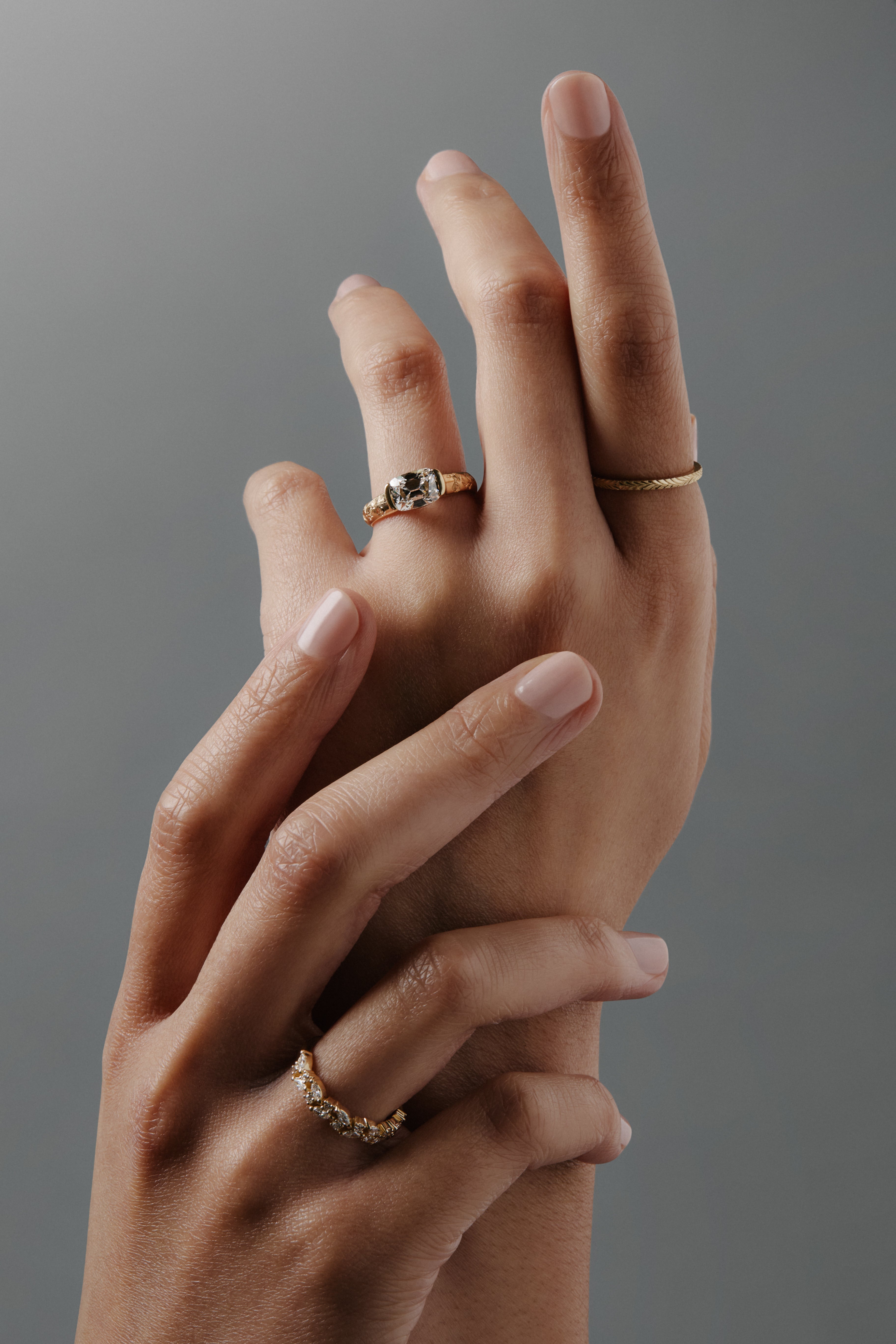 Group shot of women's hands wearing the Navette diamond cluster wedding band with round and marquise diamonds in gold. 