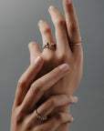 Group shot of women's hands wearing the Navette diamond cluster wedding band with round and marquise diamonds in gold. 
