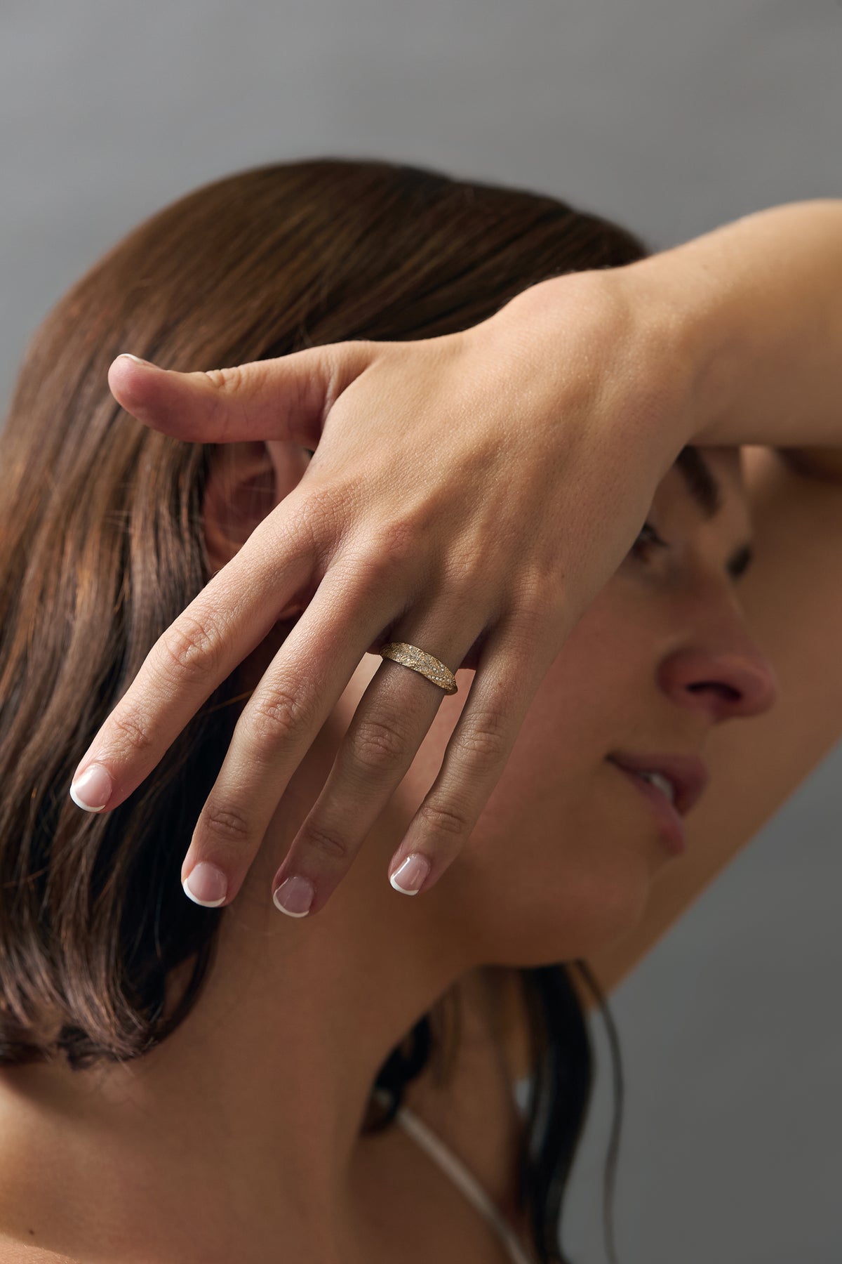 Stylized close-up of women wearing an organic textured leaf wedding band featuring Canadian diamonds