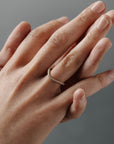 Close-up of wearing the Pernelle curved French pave diamond wedding band on her hand.