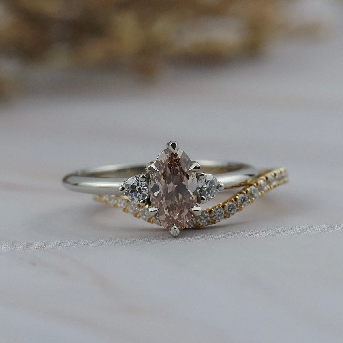 Rebecca three stone engagement ring paired with the Pernelle curved diamond pave wedding band, featuring a champagne toned moval cut diamond. 