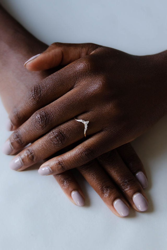 Close up of model hand wearing the Chevron Clara womens wedding band by Fluid Jewellery in yellow gold