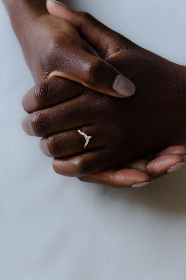 Close up of model hand wearing the Chevron Clara womens wedding band by Fluid Jewellery in yellow gold