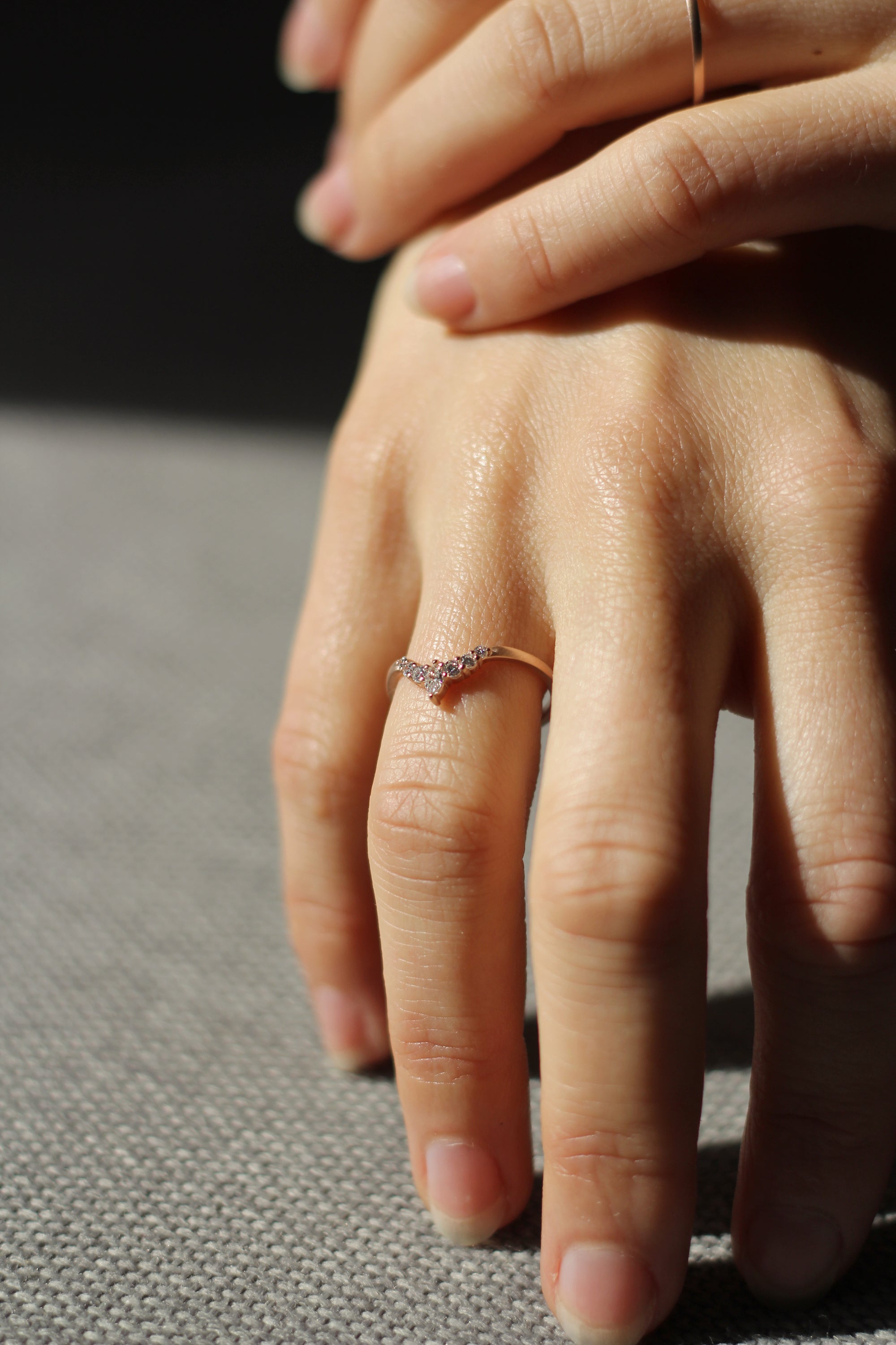 Close up of model hand wearing the Chevron Penelope womens wedding band by Fluid Jewellery in gold