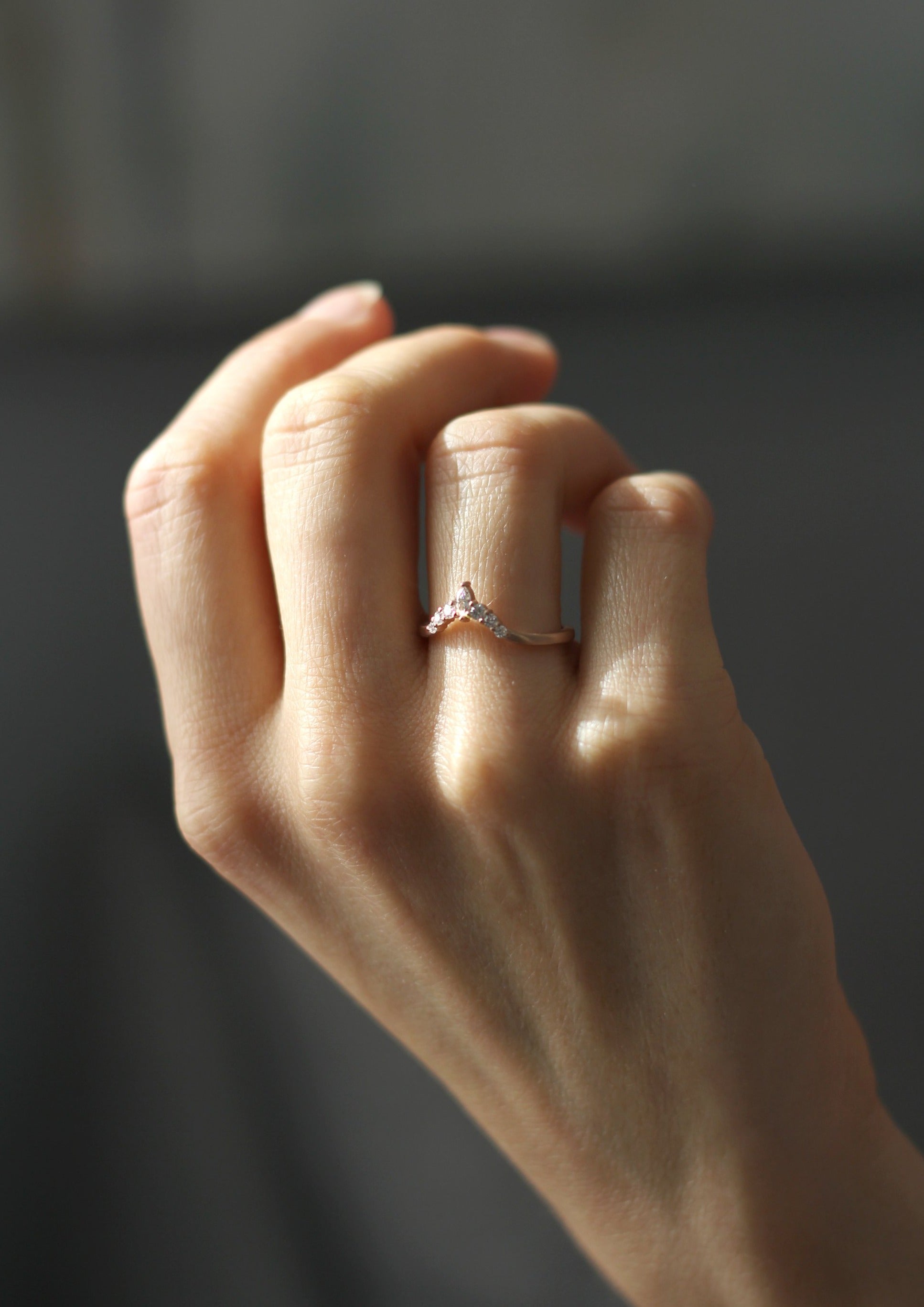 Close up of model hand wearing the Chevron Penelope womens wedding band by Fluid Jewellery in gold