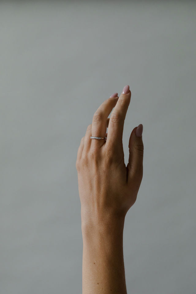 Close up of model hand wearing the classin Evelyn womens wedding band by Fluid Jewellery in gold