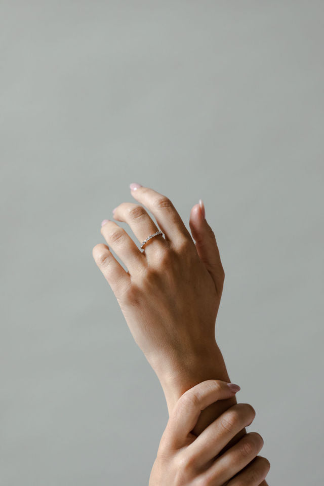 Close up of model hand wearing the cluster Marissa womens wedding band by Fluid Jewellery in yellow gold 2