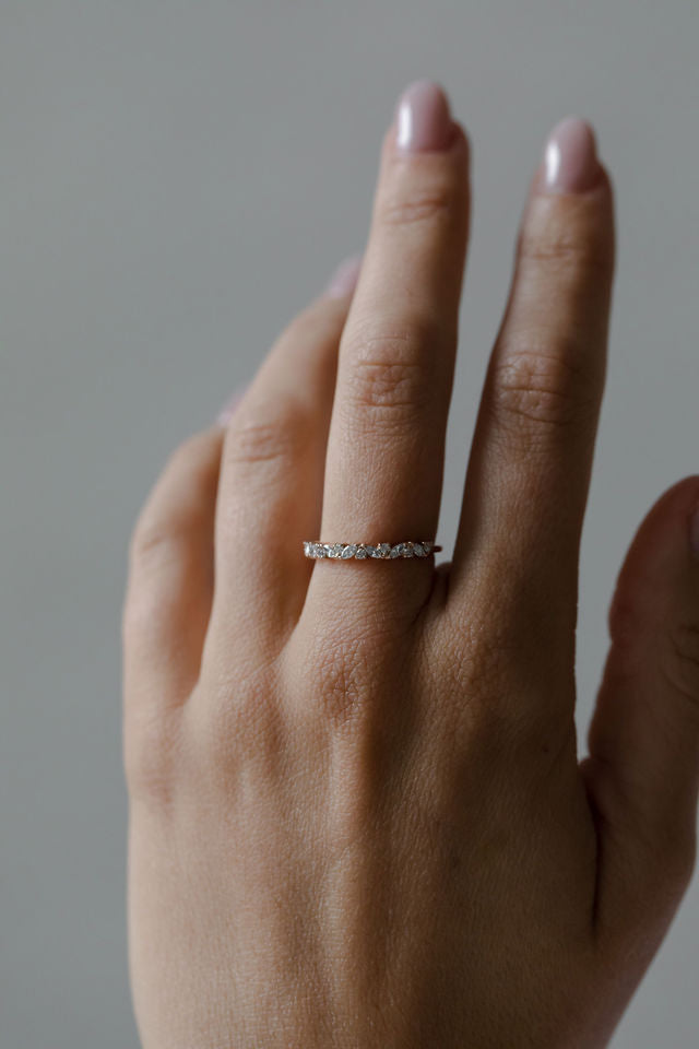 Close up of model hand wearing the cluster Marissa womens wedding band by Fluid Jewellery in yellow gold