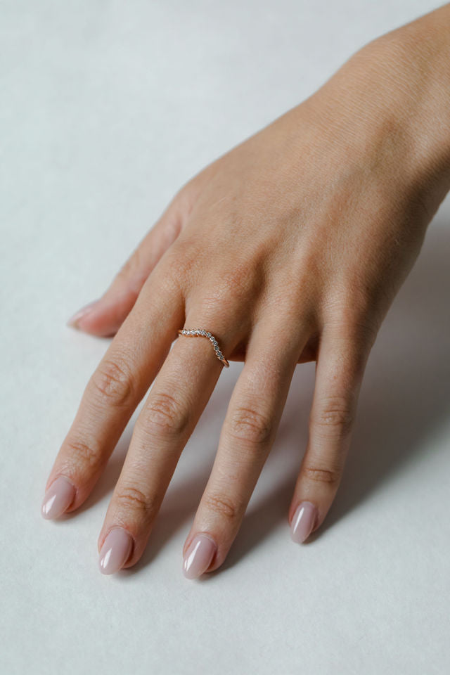 Close up of modle hand wearing the curved Ida womens wedding band by Fluid Jewellery in gold