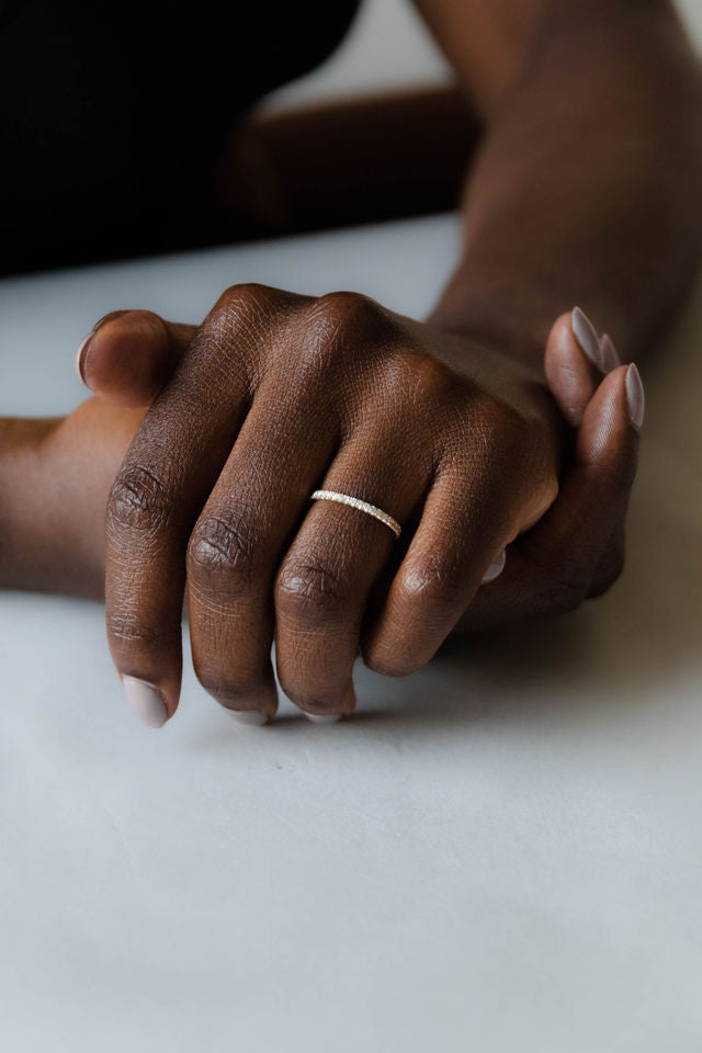 Close up of model hand wearing the classic Eternity womens wedding band by Fluid Jewellery in yellow gold